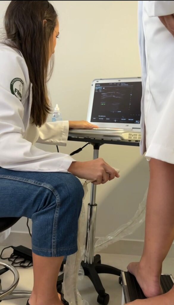Médica vascular cliente da Agência Giro 360 durante exame de ultrassom